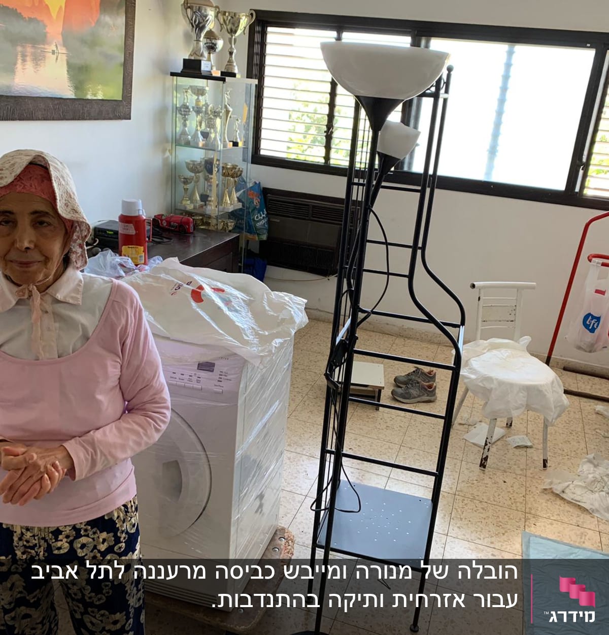 אישה עומדת ליד מכונת כביסה עטופה בניילון